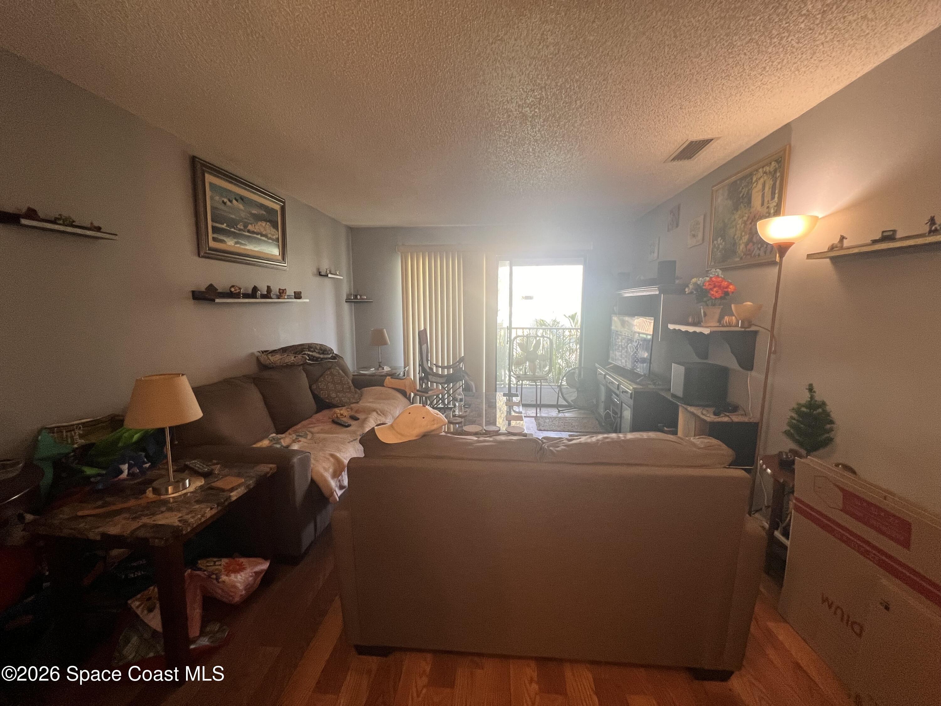 1225 North Wickham Road, Unit 623 Melbourne, FL 32935 - Photo 8 of 20 a bed room with a bed mirror and a window