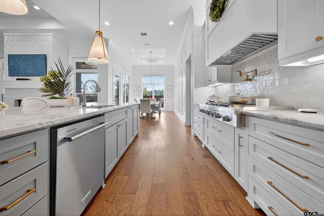 a dining room with furniture wooden floor a rug and a chandelier