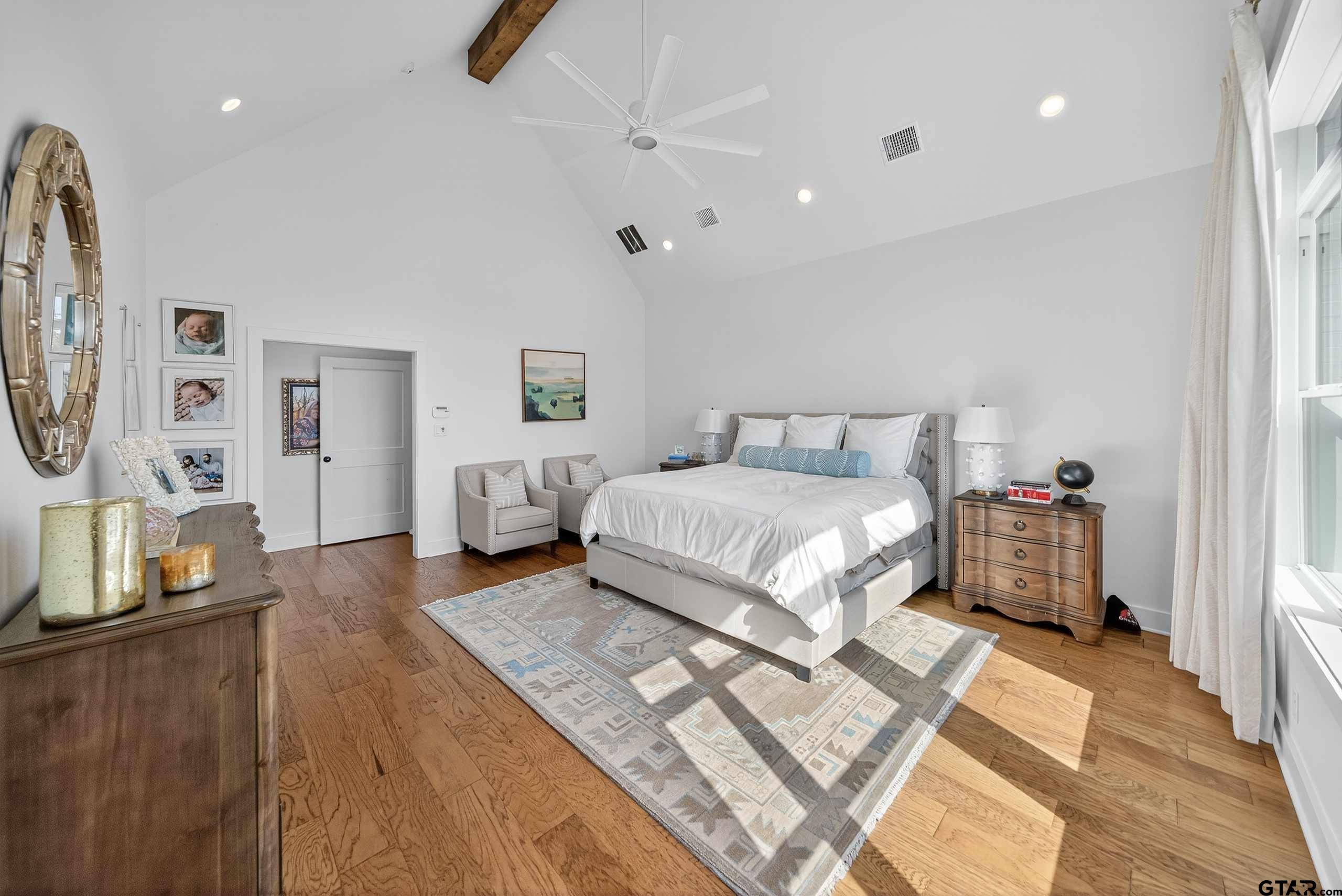 1572 Maple Lane Tyler, TX 75703 - Photo 20 of 47 a bedroom with a large bed and a chandelier