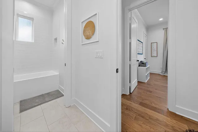 a view of a hallway with wooden floor and staircase