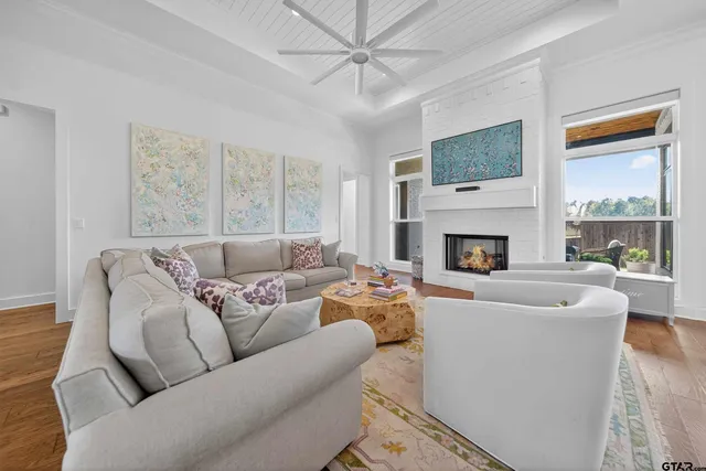 a living room with furniture a large window and a fireplace