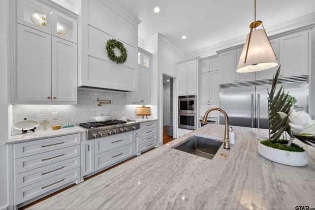 a kitchen with kitchen island granite countertop a sink a stove and cabinets