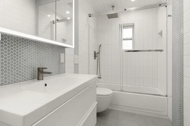 a bathroom with a white bath tub a toilet and a sink