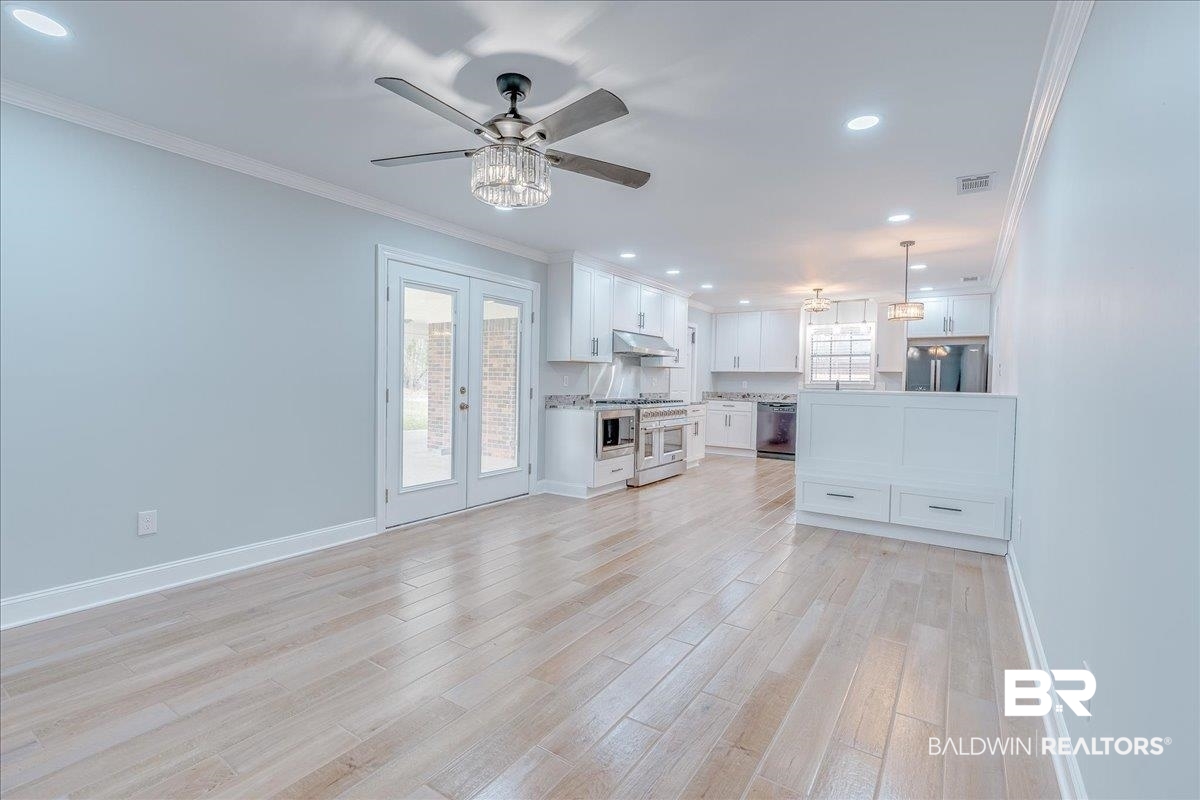 440 Dykes Road Mobile, AL 36608 - Photo 19 of 49 Unfurnished living room with crown molding, baseboards, visible vents, and light wood finished floors