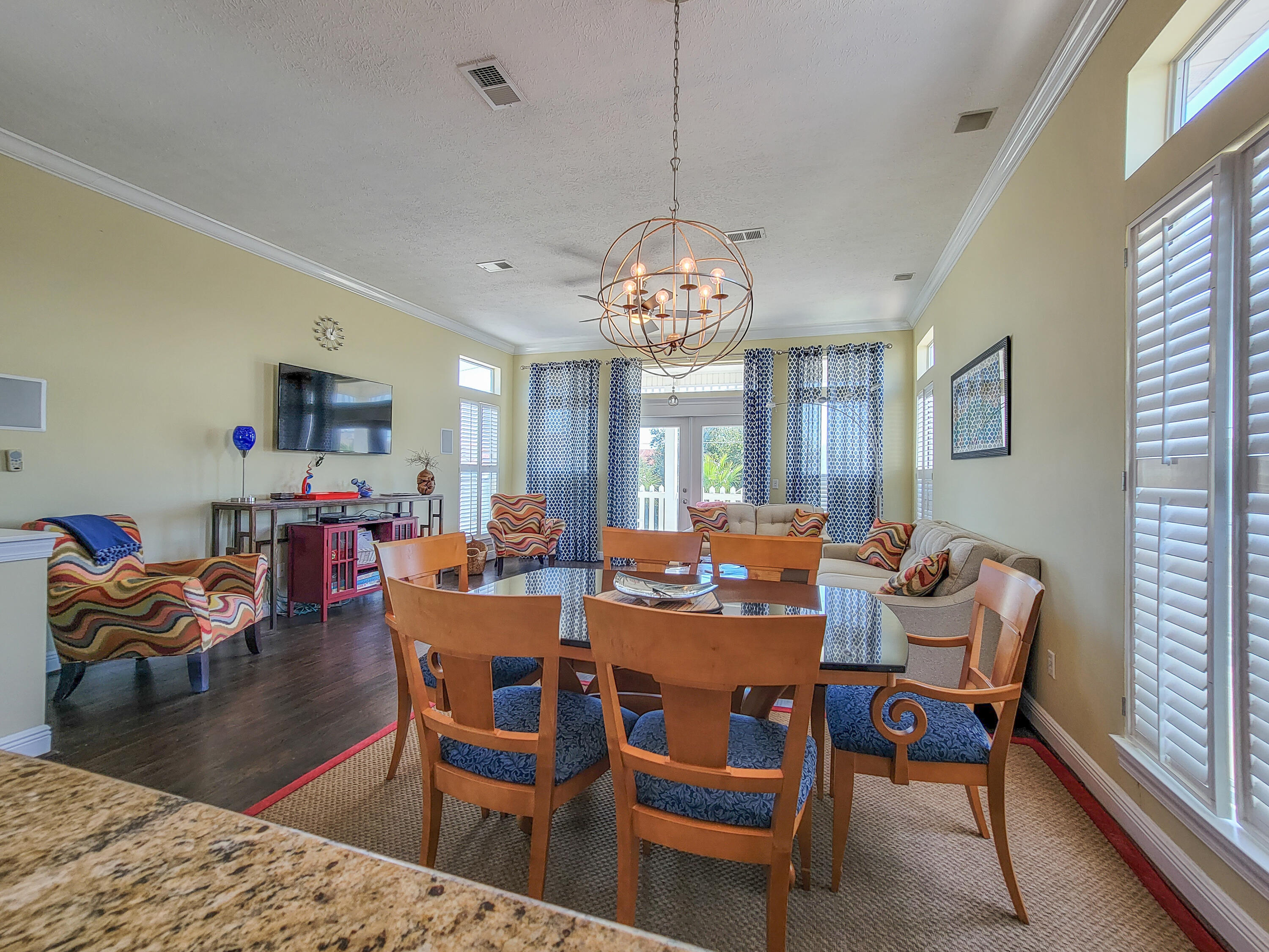 3567 East County Highway 30A Santa Rosa Beach, FL 32459 - Photo 4 of 31 a dining room with wooden floor a chandelier a wooden table and chairs