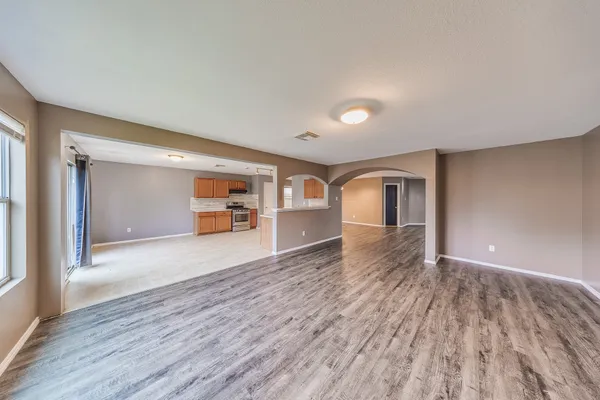 a view of empty room with wooden floor