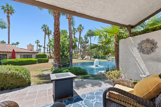 a view of a patio with couches table and chairs and potted plants