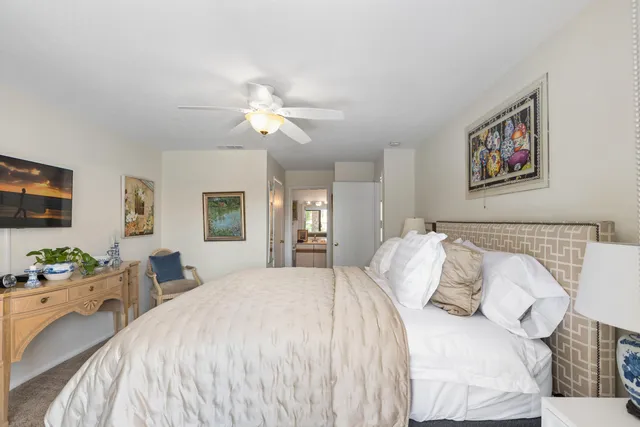 a bedroom with a bed mirror and window