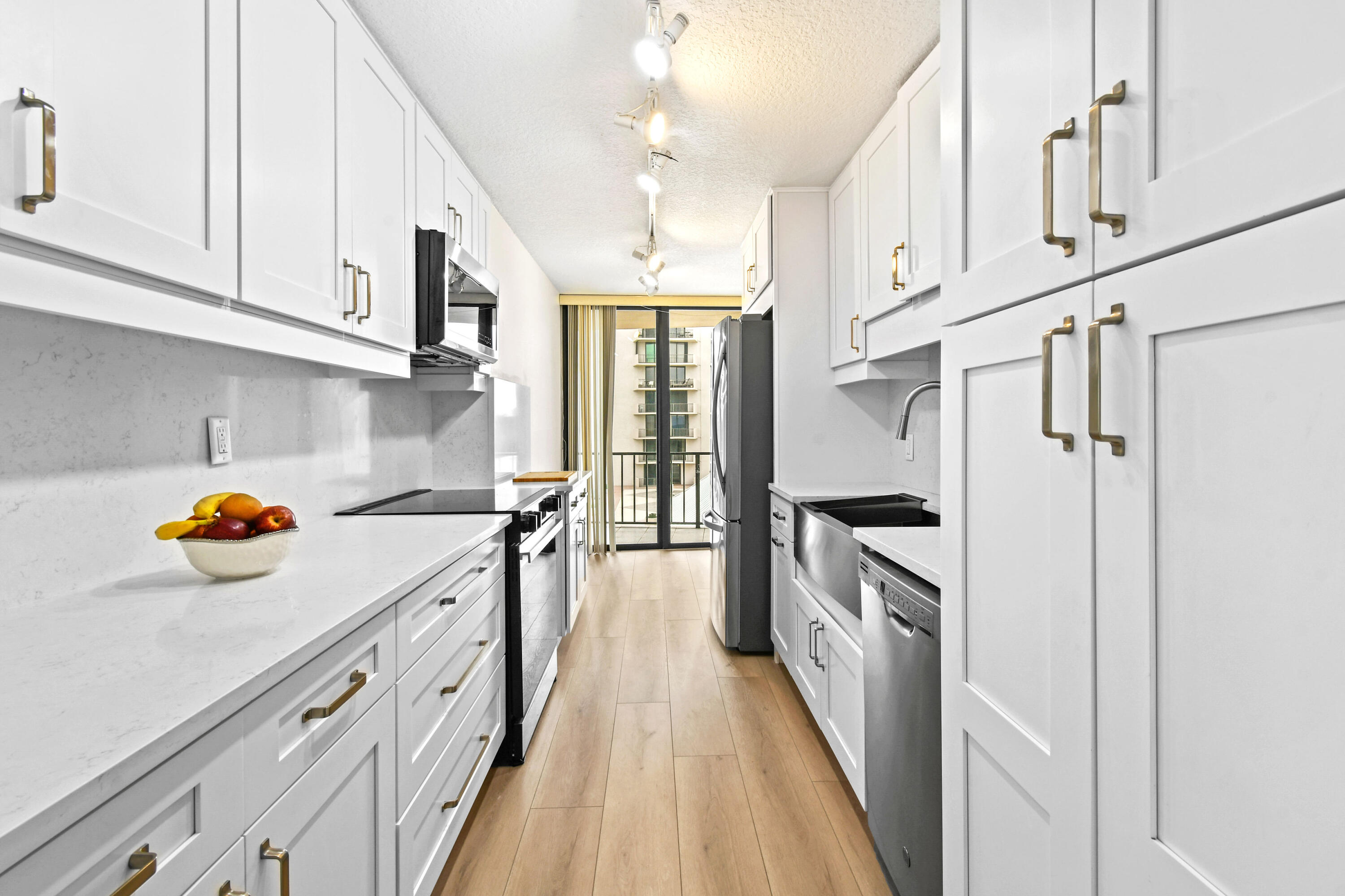 4200 North Ocean Drive, Unit 1 Riviera Beach, FL 33404 - Photo 29 of 59 a kitchen with granite countertop white cabinets and stainless steel appliances