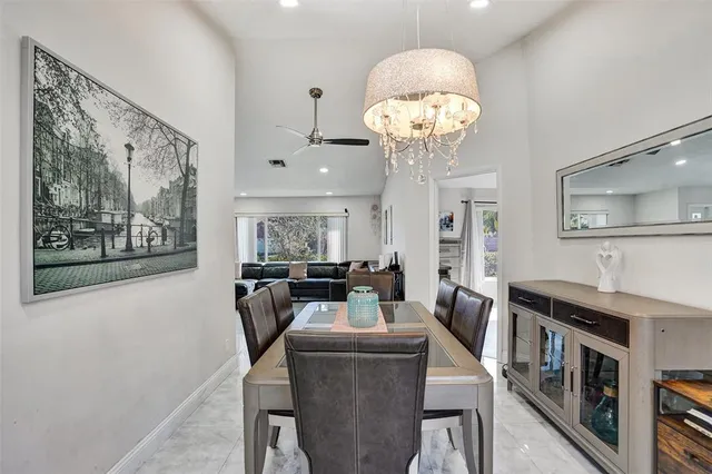a view of a dining room with furniture a kitchen and chandelier
