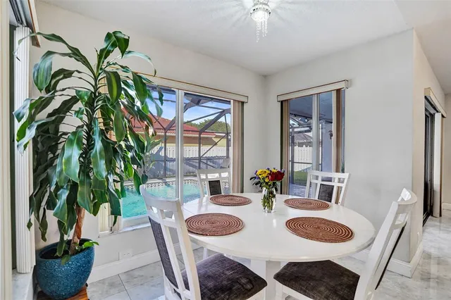 a dining room with furniture and a potted plant