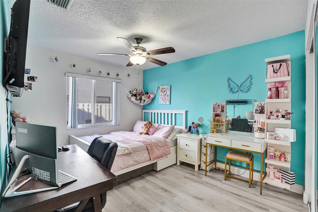 7909 Northwest 19th Street Margate, FL 33063 - Photo 23 of 33 a bedroom with a bed and a desk