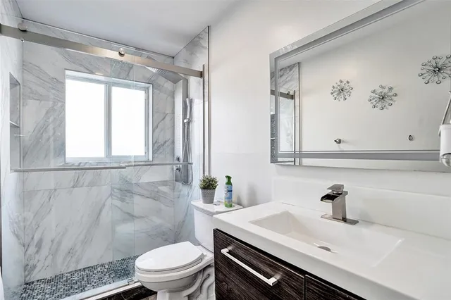 a bathroom with a sink a toilet and a mirror