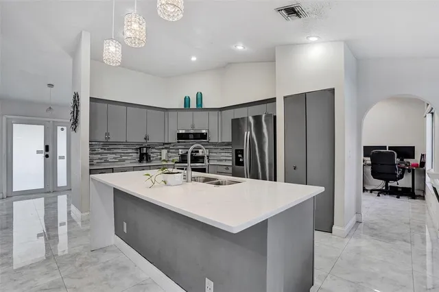 a kitchen with refrigerator and chairs