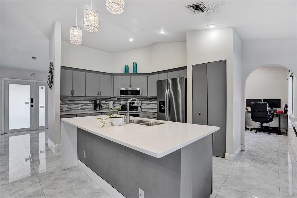 7909 Northwest 19th Street Margate, FL 33063 - Photo 7 of 33 a kitchen with refrigerator and chairs