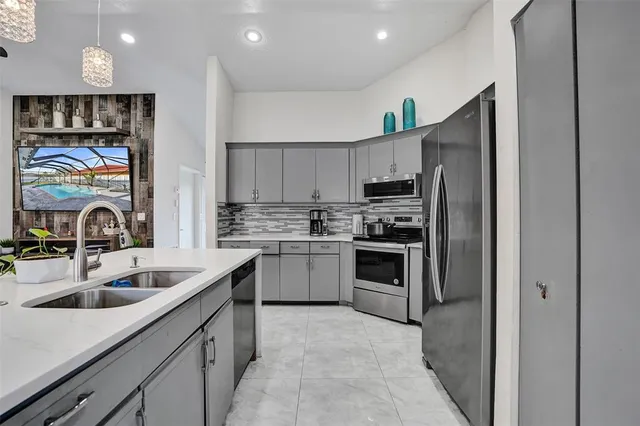 a kitchen with stainless steel appliances granite countertop a sink and a refrigerator
