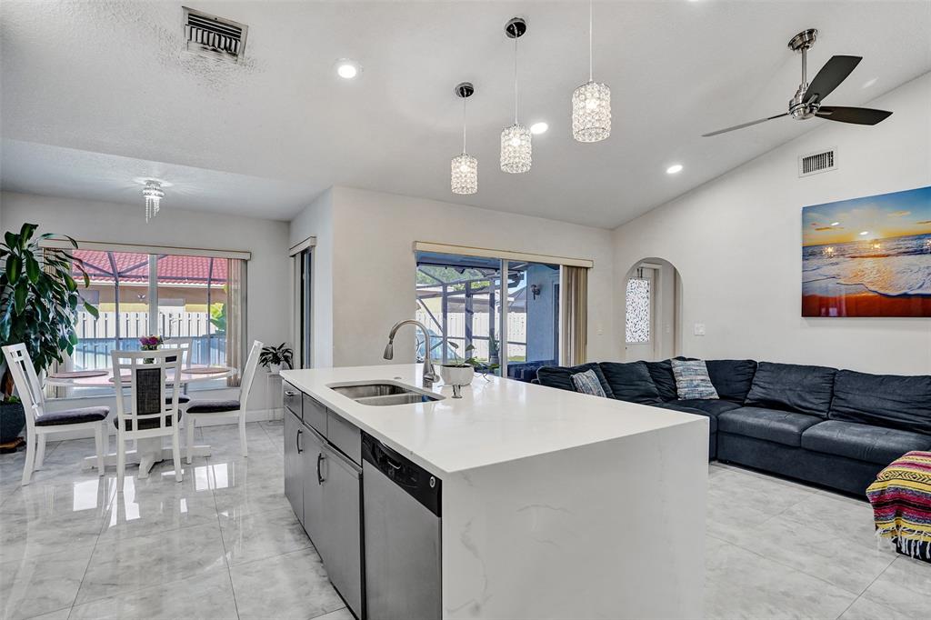 7909 Northwest 19th Street Margate, FL 33063 - Photo 9 of 33 a living room with furniture a flat screen tv and kitchen view