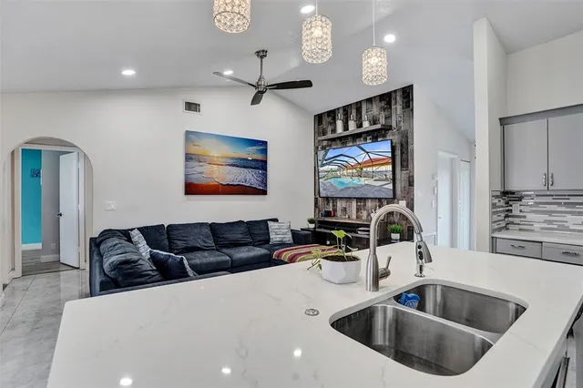 a kitchen with stainless steel appliances a sink a microwave a dining table and chairs