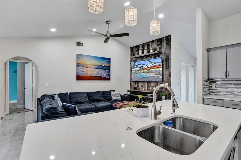 7909 Northwest 19th Street Margate, FL 33063 - Photo 10 of 33 a kitchen with stainless steel appliances a sink a microwave a dining table and chairs