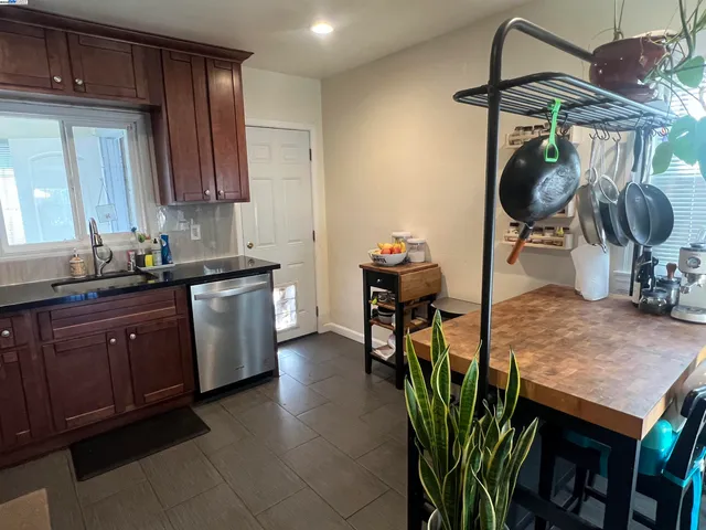 a kitchen with stainless steel appliances granite countertop a sink dishwasher and cabinets with wooden floor