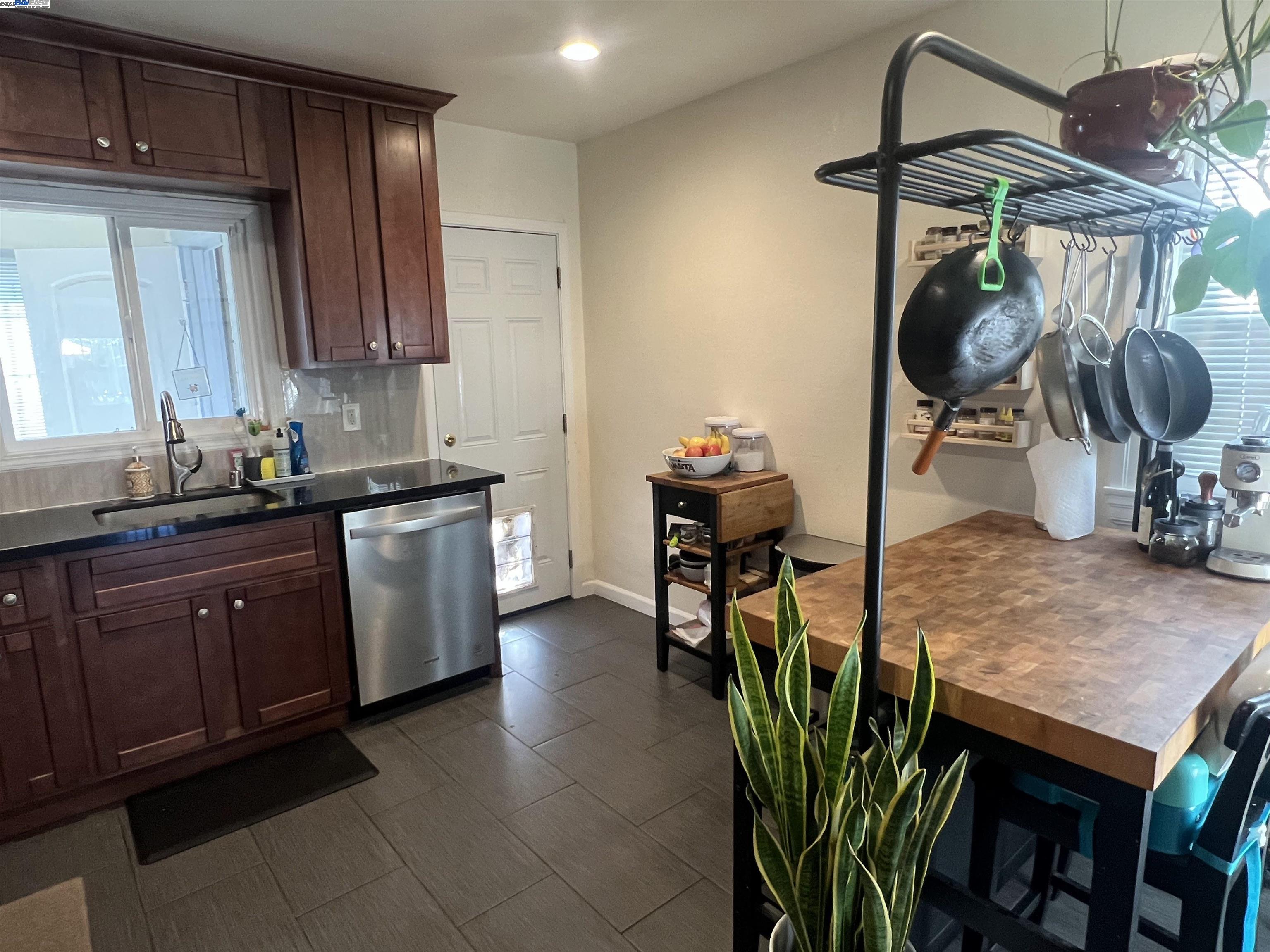 3229 MacArthur Boulevard Oakland, CA 94602 - Photo 5 of 9 a kitchen with stainless steel appliances granite countertop a sink dishwasher and cabinets with wooden floor