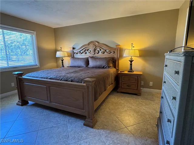 a spacious bedroom with a bed and a cabinets