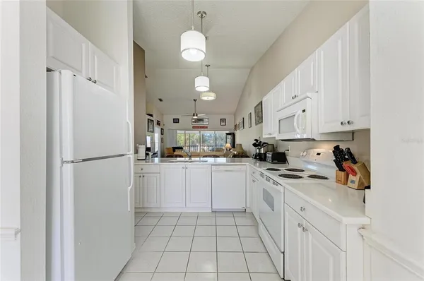 a kitchen with white cabinets and window