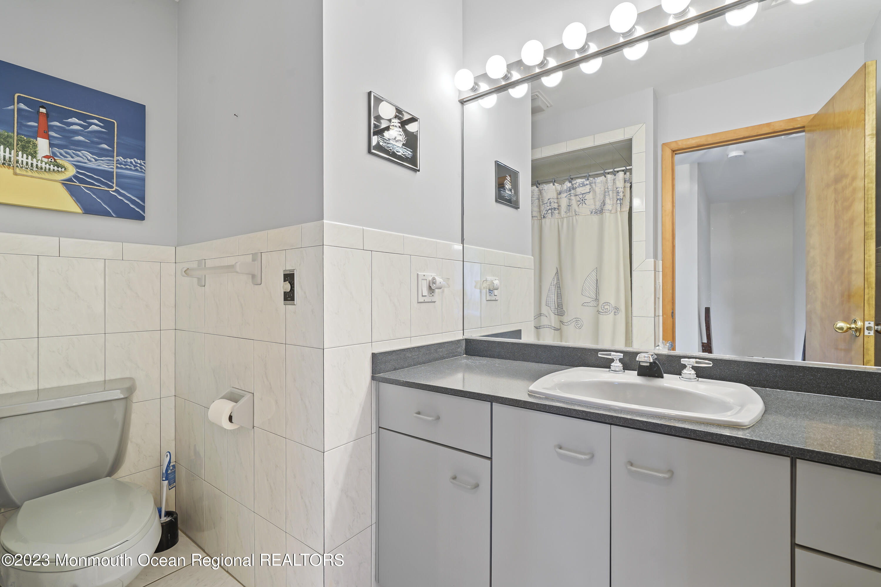 306 Ormond Drive Lavallette, NJ 08735 - Photo 2 of 49 a bathroom with a granite countertop sink a toilet a mirror a vanity and shower