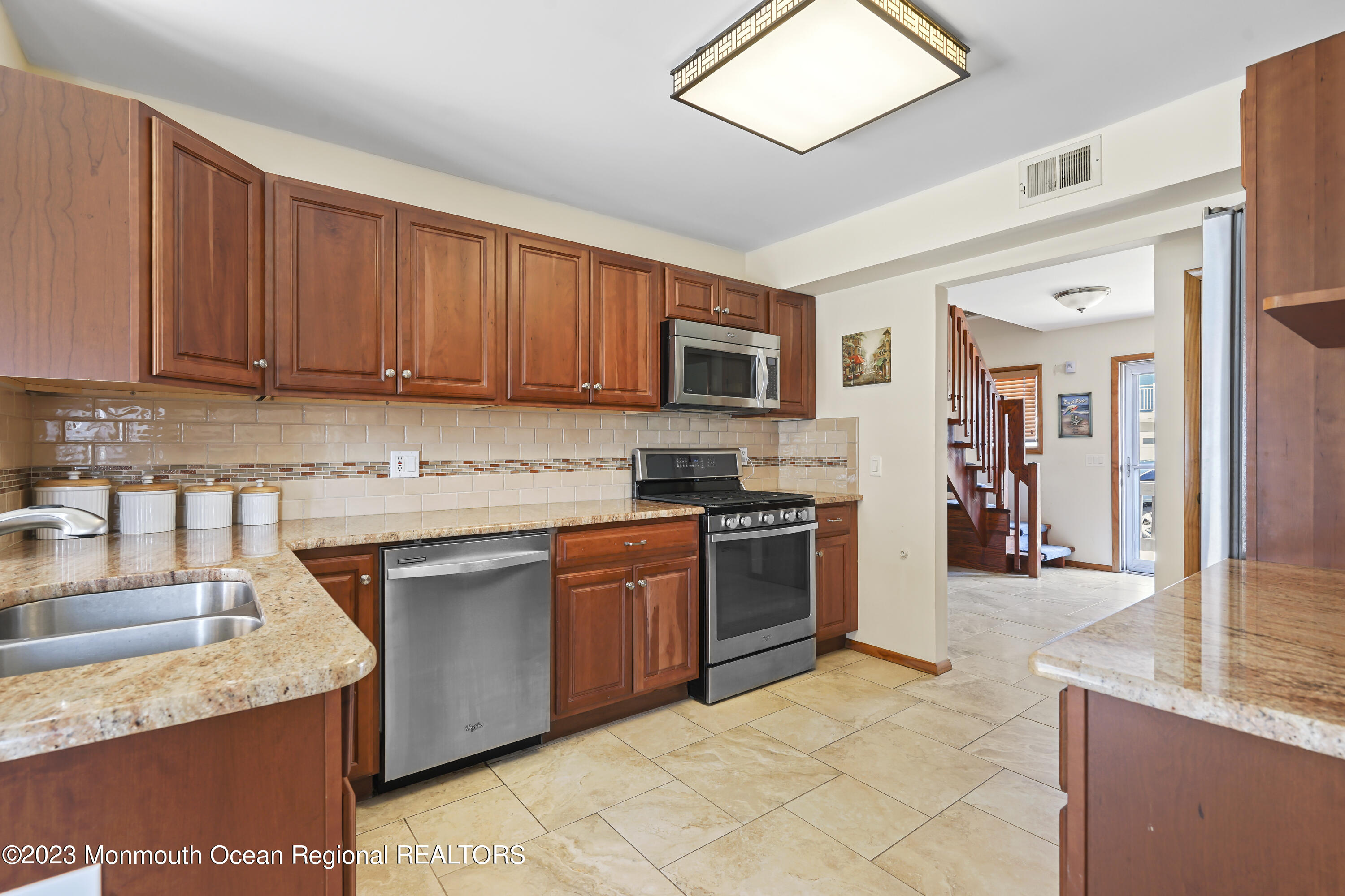 306 Ormond Drive Lavallette, NJ 08735 - Photo 31 of 49 a kitchen with stainless steel appliances granite countertop a stove top oven a sink dishwasher and a refrigerator with wooden cabinets