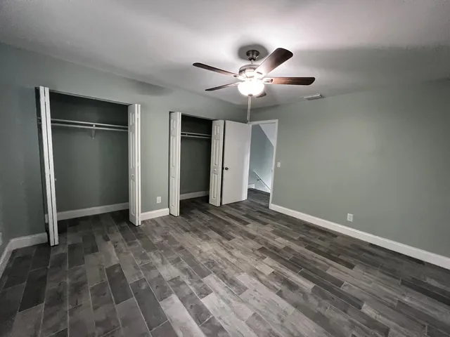 an empty room with closet and a ceiling fan