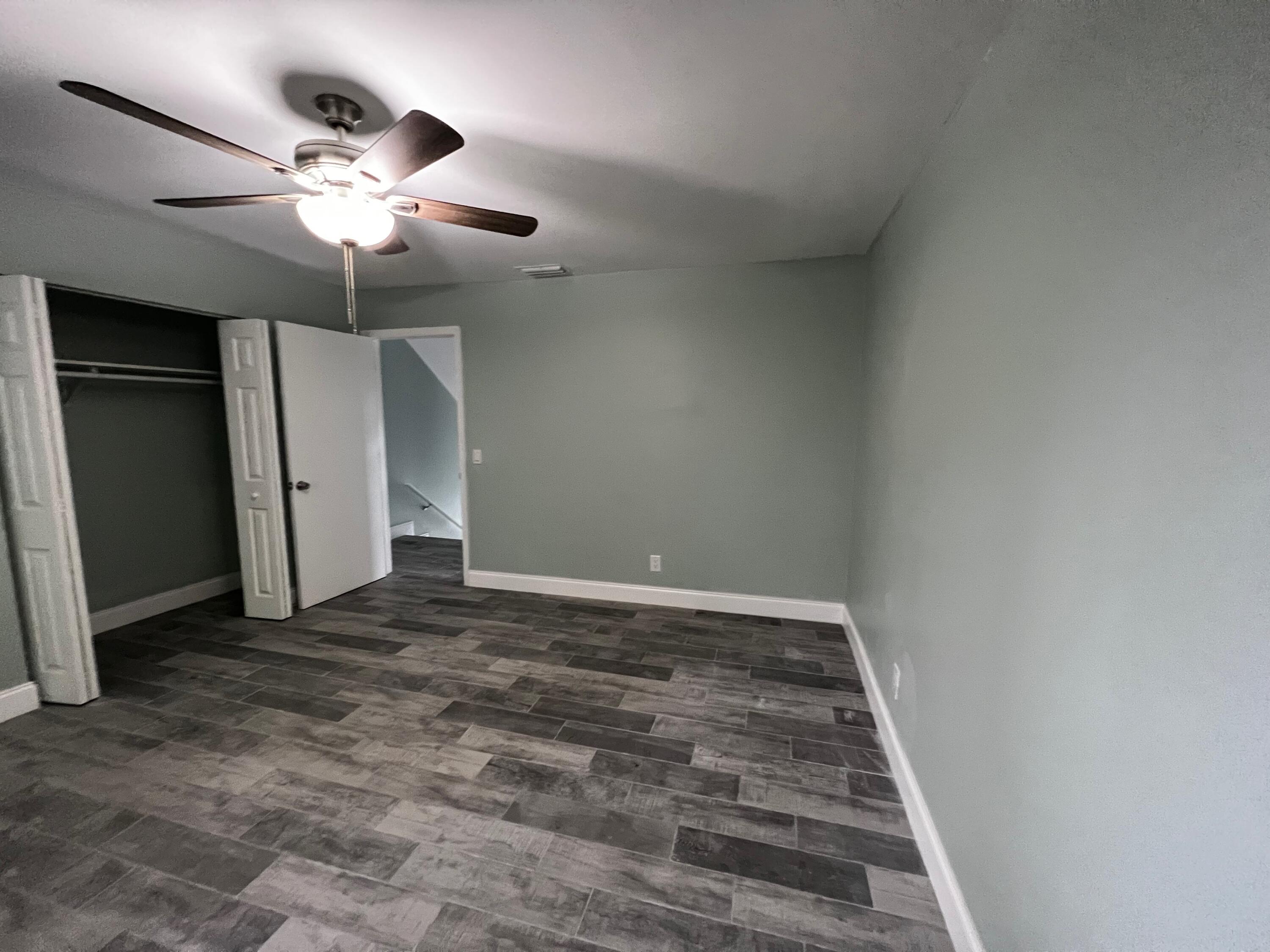 1147 Goldenrod Road Wellington, FL 33414 - Photo 14 of 18 an empty room with a chandelier fan and a bathroom