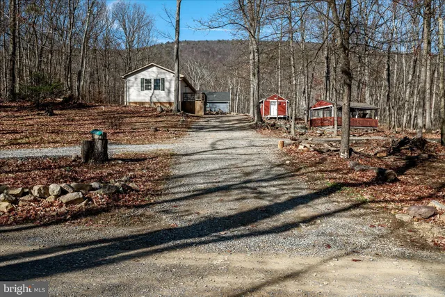 a front view of a house with large trees