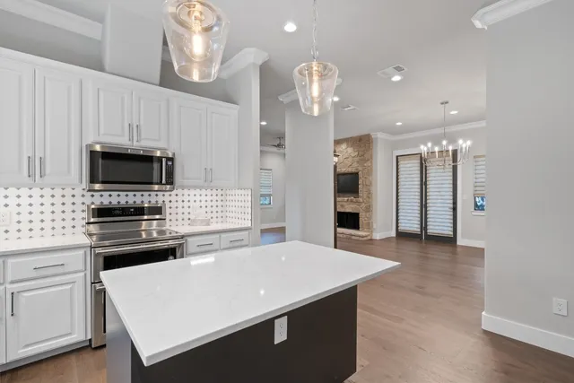 a kitchen with stainless steel appliances a stove sink microwave and cabinets