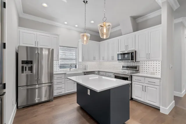 a kitchen with kitchen island white cabinets stainless steel appliances and sink