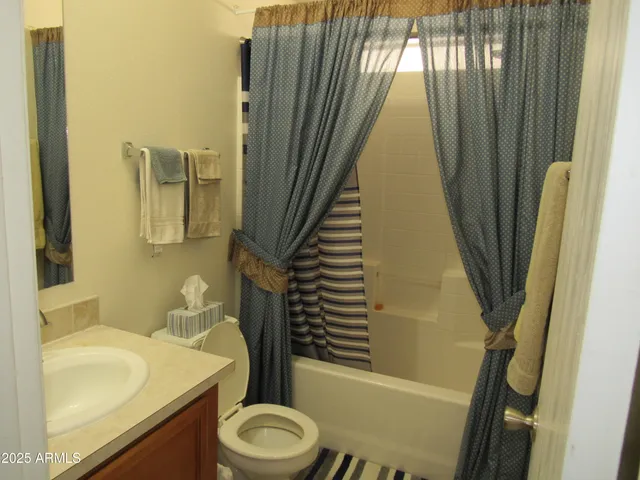 a bathroom with a sink a toilet a mirror and shower