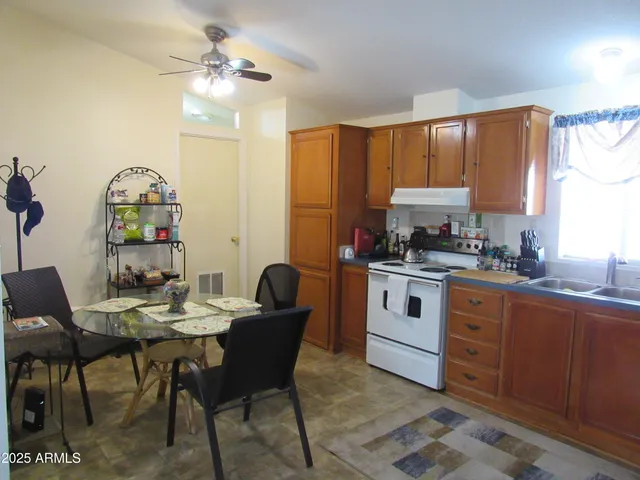 a kitchen with a stove a table and chairs in it