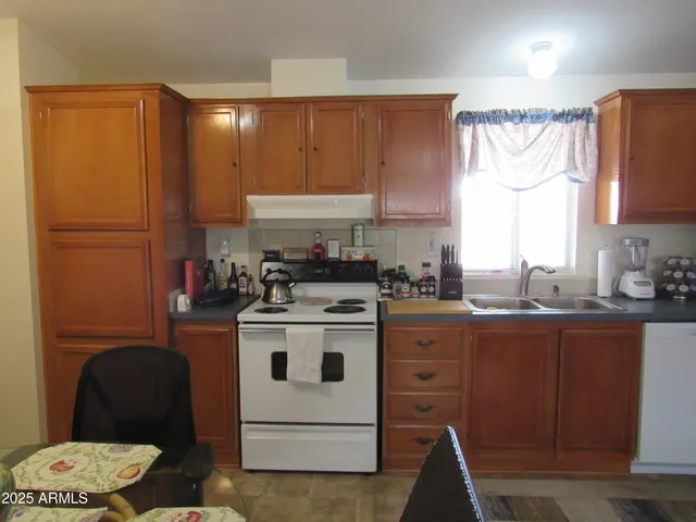 a kitchen with a stove a sink and a refrigerator