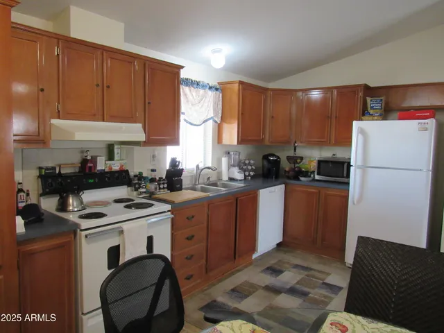 a kitchen with a refrigerator stove top oven and sink