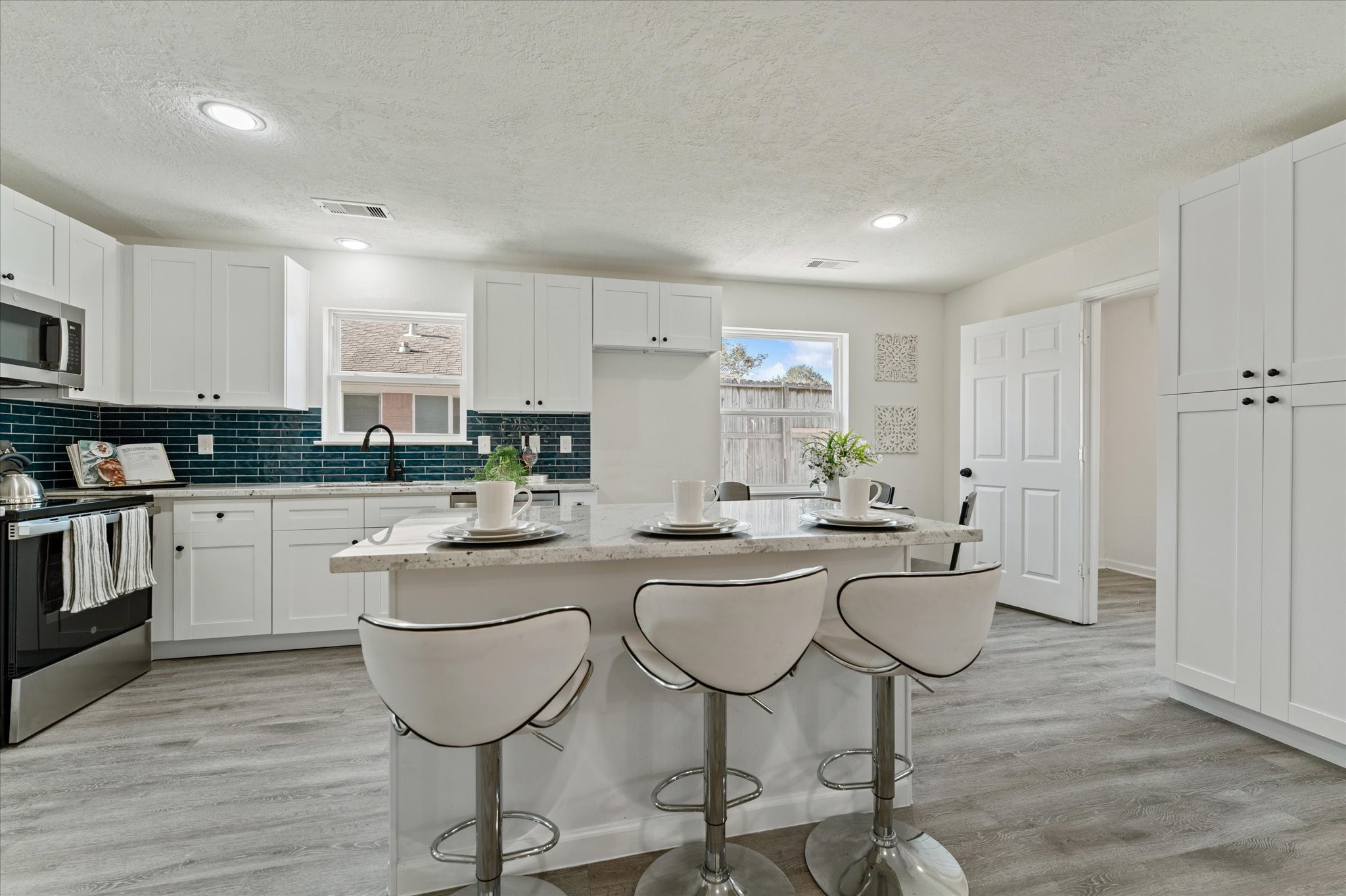 6030 Beaudry Drive Houston, TX 77035 - Photo 15 of 45 a kitchen with stainless steel appliances kitchen island granite countertop a stove a sink a refrigerator and white cabinets with wooden floor