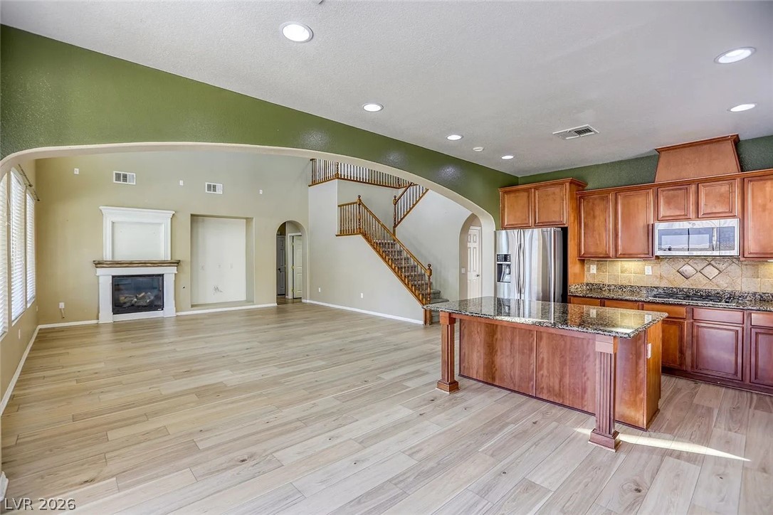 692 Blue Crystal Creek Road Henderson, NV 89002 - Photo 29 of 29 Kitchen featuring open floor plan, dark stone countertops, a kitchen island, stainless steel appliances, and recessed lighting