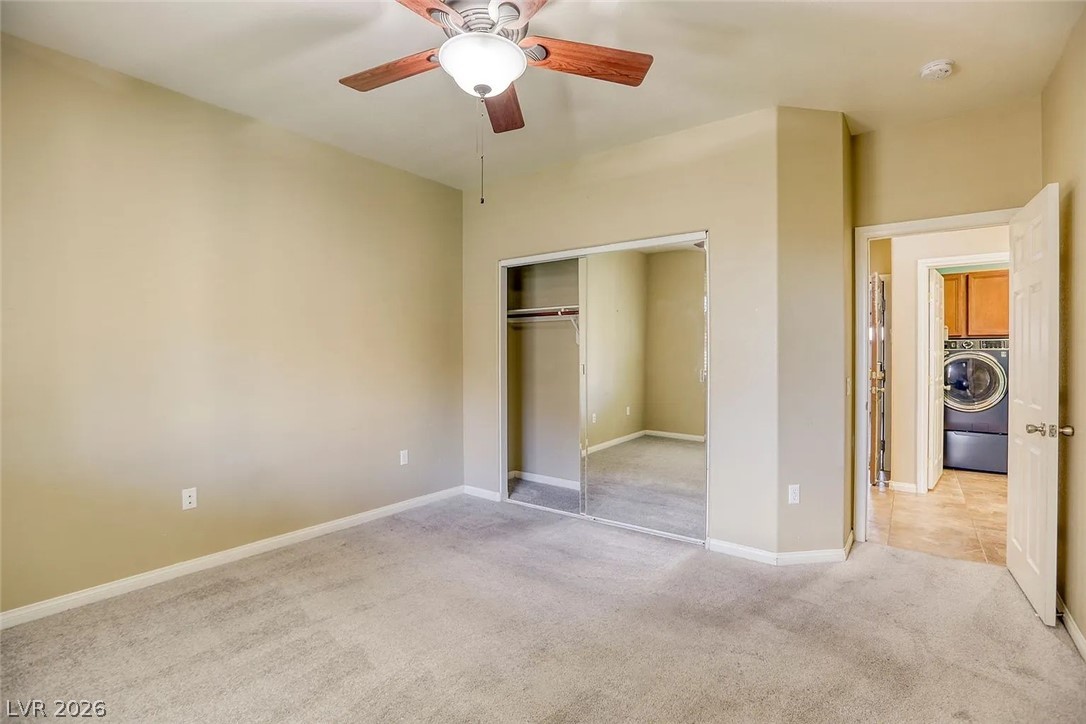 692 Blue Crystal Creek Road Henderson, NV 89002 - Photo 26 of 29 Unfurnished bedroom with light colored carpet, washer / clothes dryer, ceiling fan, and a closet