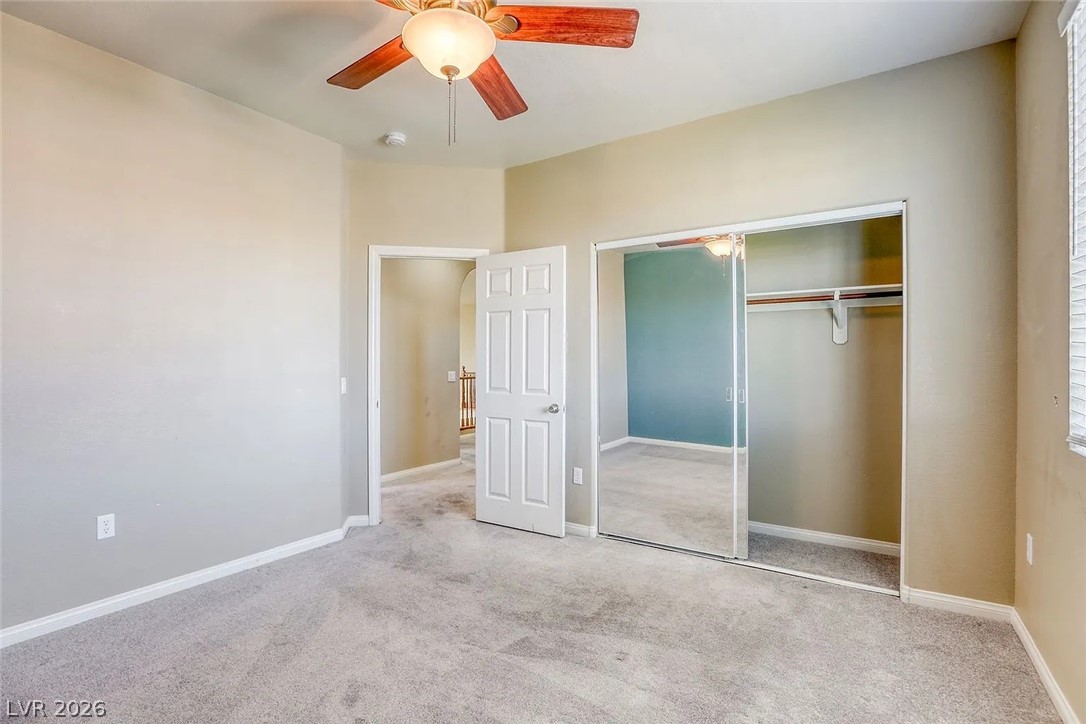692 Blue Crystal Creek Road Henderson, NV 89002 - Photo 27 of 29 Unfurnished bedroom featuring carpet floors, a closet, and a ceiling fan