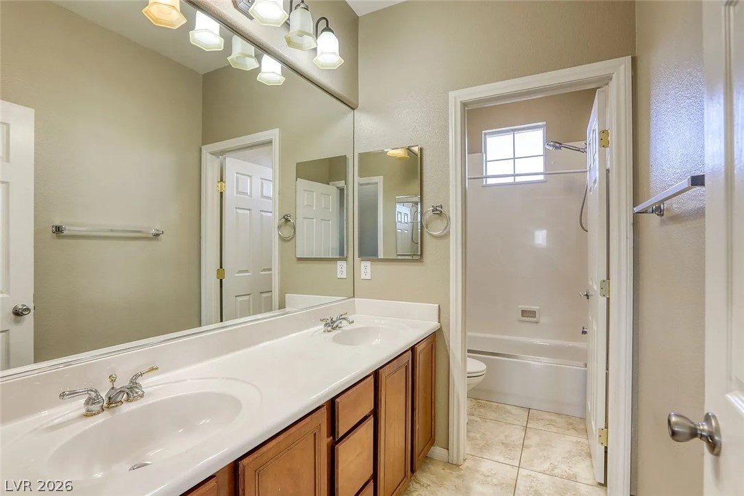 692 Blue Crystal Creek Road Henderson, NV 89002 - Photo 3 of 29 Bathroom with double vanity, shower / washtub combination, and light tile patterned floors