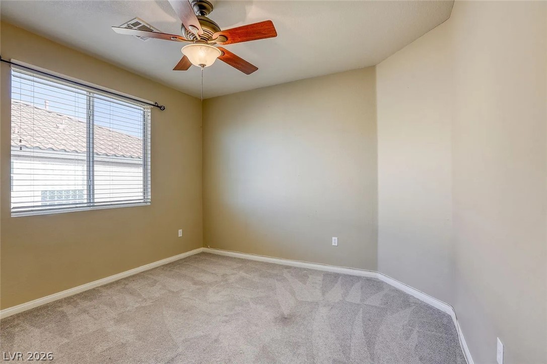 692 Blue Crystal Creek Road Henderson, NV 89002 - Photo 5 of 29 Unfurnished room with a ceiling fan and light carpet