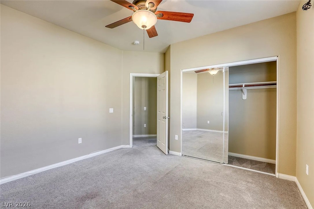 692 Blue Crystal Creek Road Henderson, NV 89002 - Photo 6 of 29 Unfurnished bedroom featuring carpet flooring, a closet, and a ceiling fan