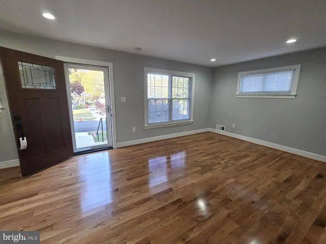 a view of a hallway with wooden floor and closet
