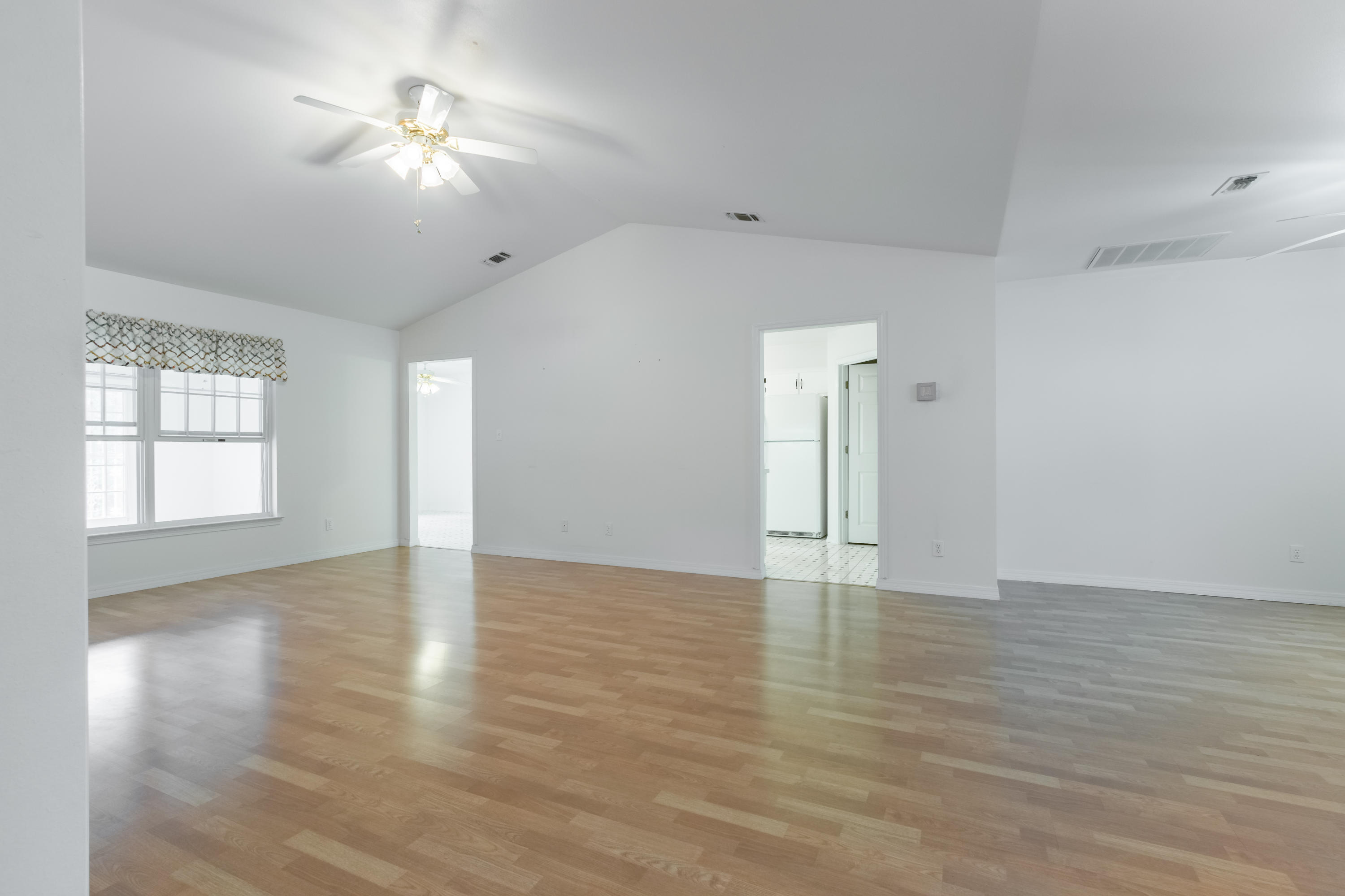 5909 Old Bethel Road Crestview, FL 32536 - Photo 4 of 47 a view of an empty room with a window and wooden floor