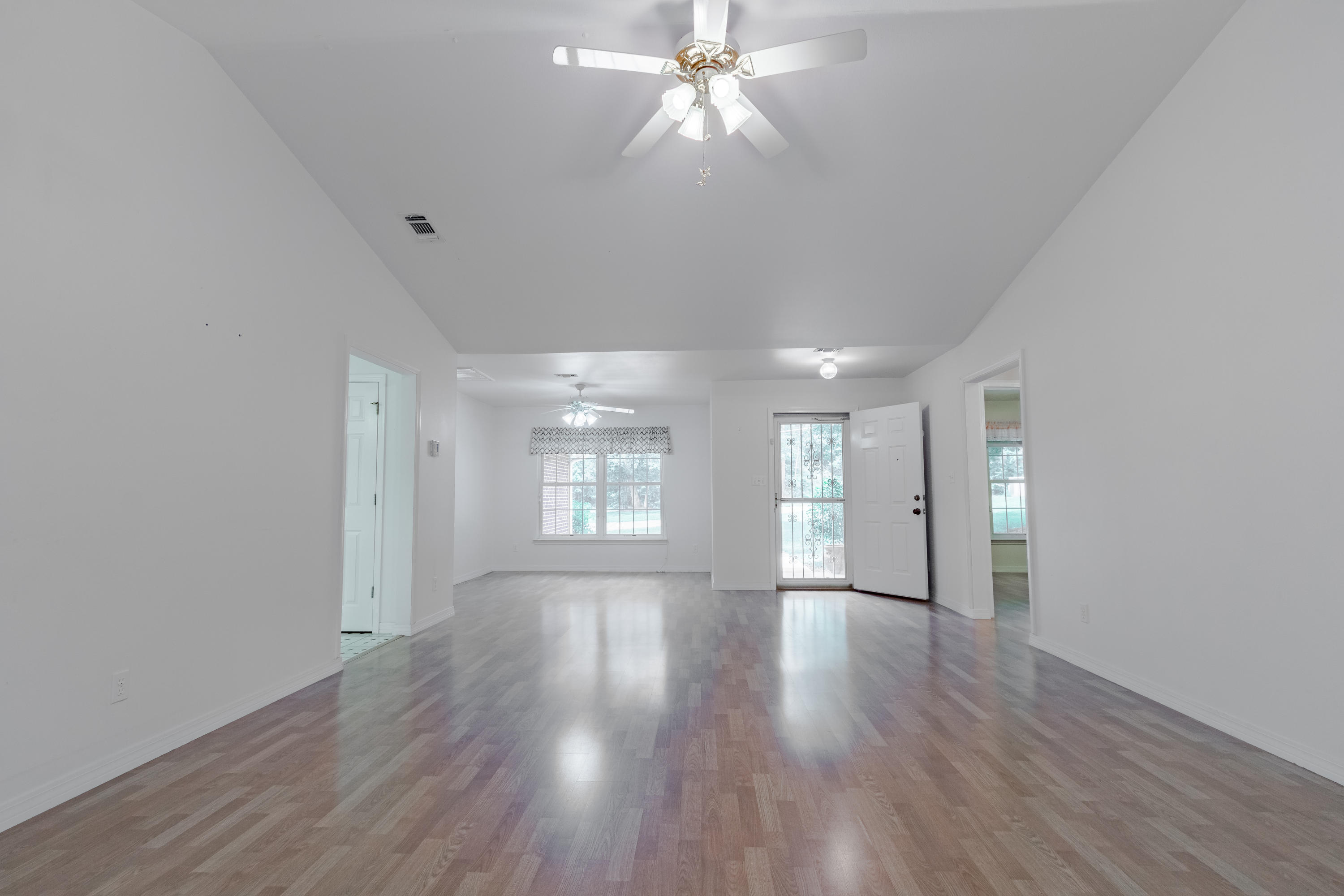 5909 Old Bethel Road Crestview, FL 32536 - Photo 5 of 47 a view of an empty room with wooden floor and a window