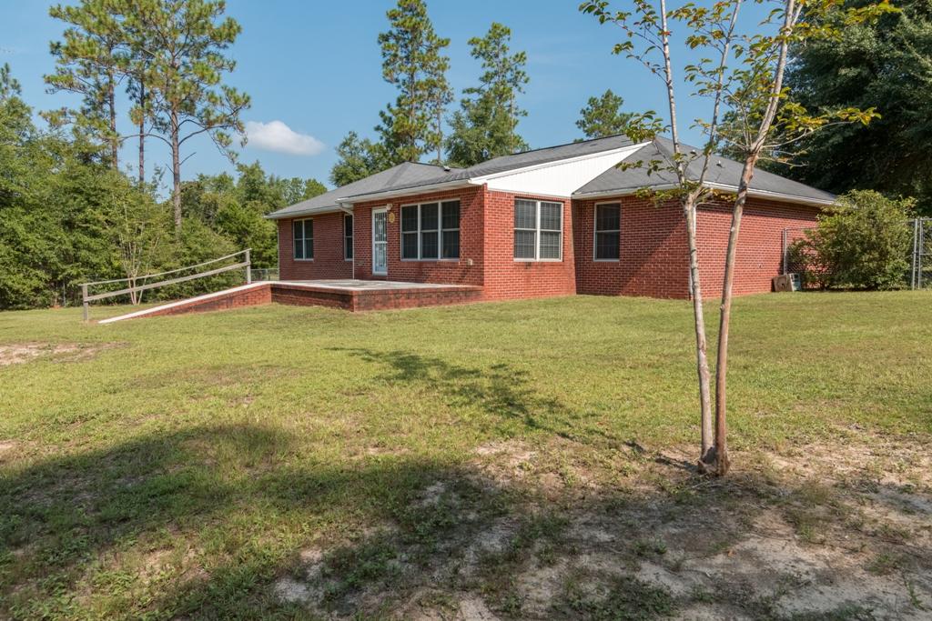 5909 Old Bethel Road Crestview, FL 32536 - Photo 6 of 47 a backyard of a house with table and chairs under an umbrella