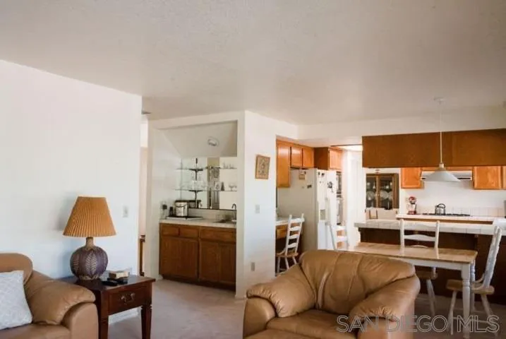 1615 Fuerte Ranch Road El Cajon, CA 92019 - Photo 3 of 17 a living room with stainless steel appliances furniture a rug and a kitchen view